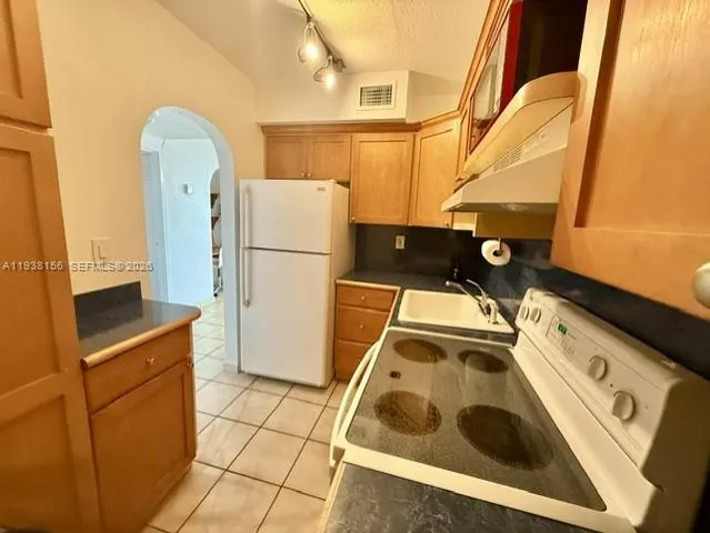 a kitchen with a stove sink and cabinets