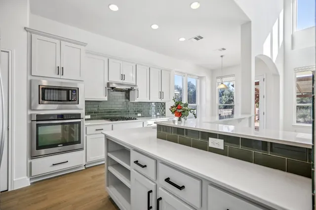 a kitchen with granite countertop white cabinets and white appliances