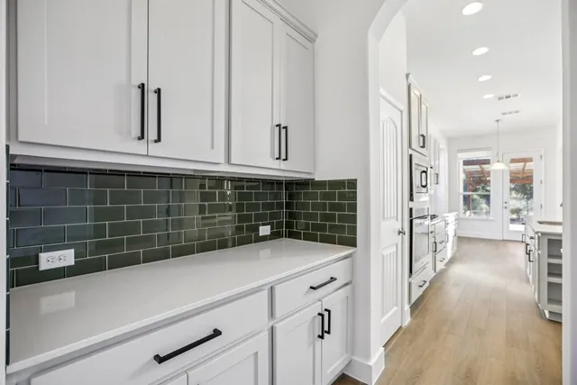 a view of a hallway with wooden floor and entryway