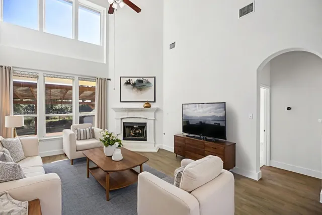 a living room with furniture a flat screen tv and a fireplace