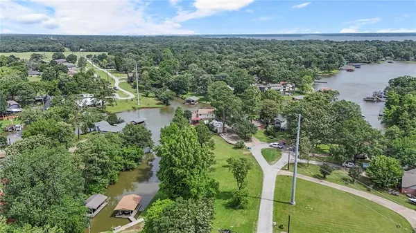 an aerial view of a house with a yard and lake view