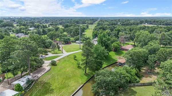 an aerial view of residential houses with outdoor space and trees