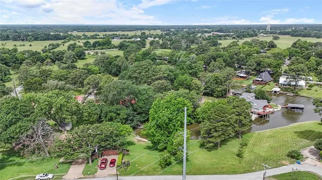 an aerial view of a house with a yard and lake view