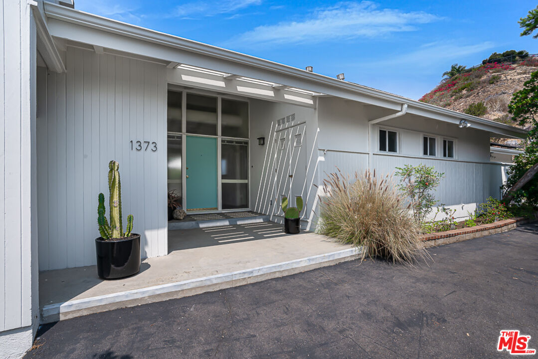 front view of a house with potted plants
