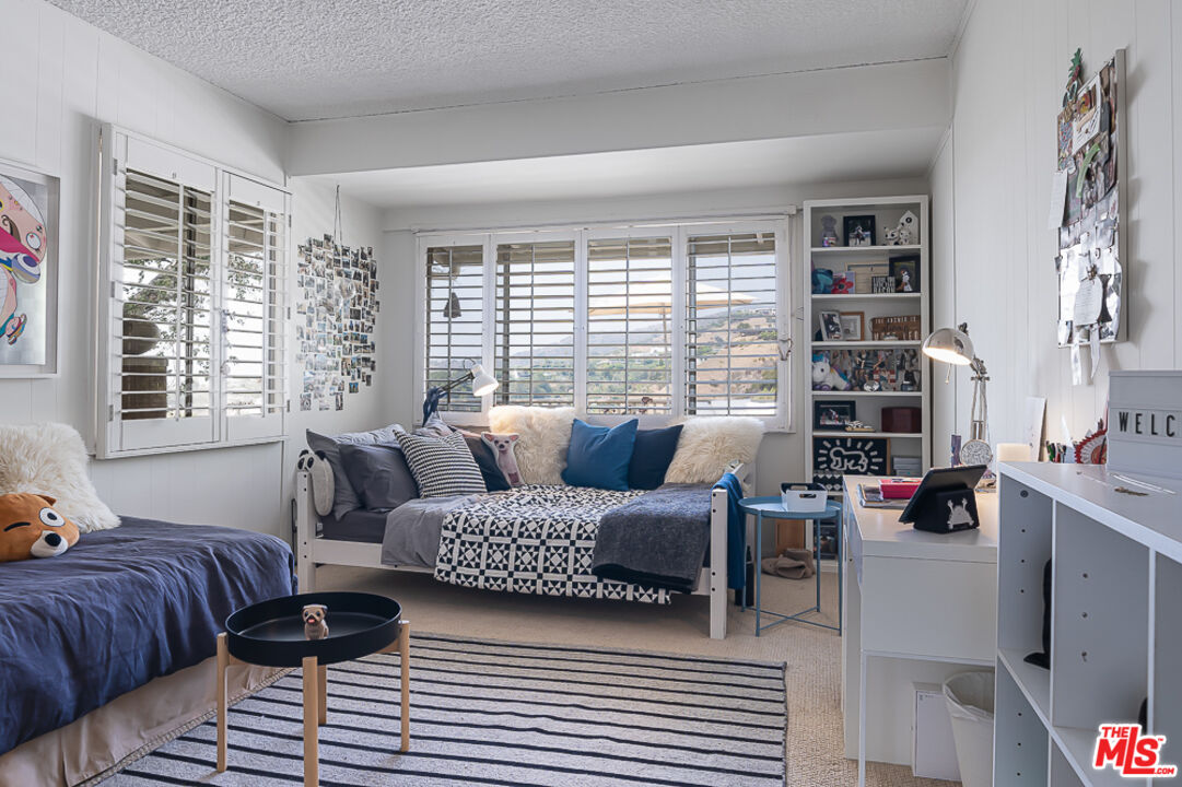 1373 Las Canoas Road Pacific Palisades, CA 90272 - Photo 15 of 19 a bedroom with a bed and a couch