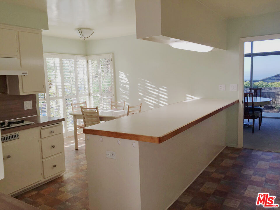1373 Las Canoas Road Pacific Palisades, CA 90272 - Photo 10 of 19 a kitchen with stainless steel appliances granite countertop a sink and cabinets
