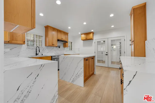 a kitchen with stainless steel appliances granite countertop a sink and a stove top oven