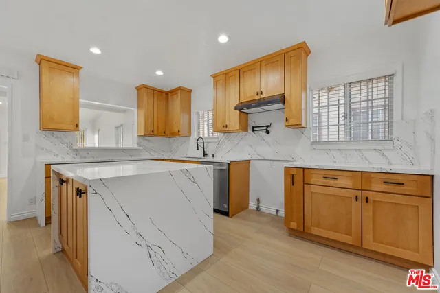 a kitchen with stainless steel appliances granite countertop a sink stove and wooden cabinets