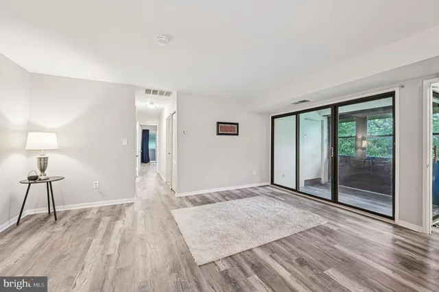 a view of empty room with wooden floor
