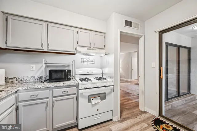 a kitchen with white cabinets and appliances