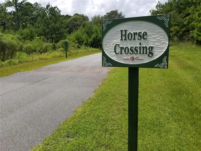 a view of a sign in a park next to a road