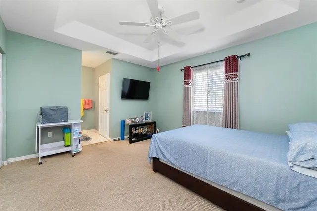 a bedroom with a bed a flat screen tv and a fireplace