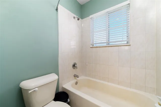 a white toilet sitting next to a bath tub