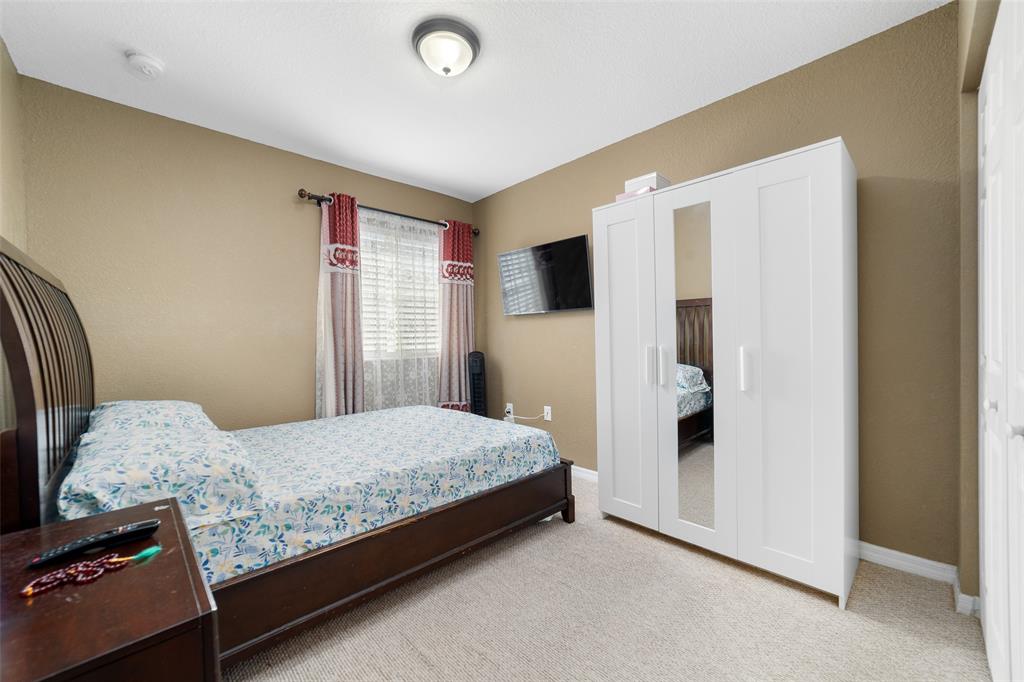 8915 Southwest 19th Street, Unit 8915 Miramar, FL 33025 - Photo 15 of 27 a bedroom with a bed and a refrigerator