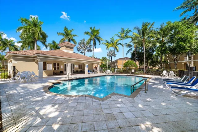 a view of a house with pool and sitting area