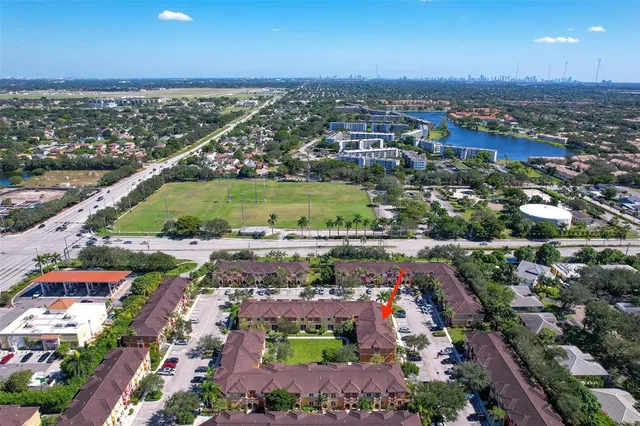 an aerial view of a city with lots of residential buildings ocean and mountain view in back