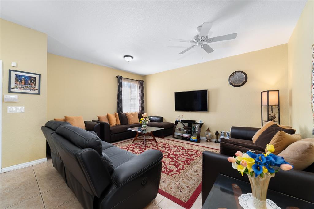8915 Southwest 19th Street, Unit 8915 Miramar, FL 33025 - Photo 3 of 27 a living room with furniture and a flat screen tv