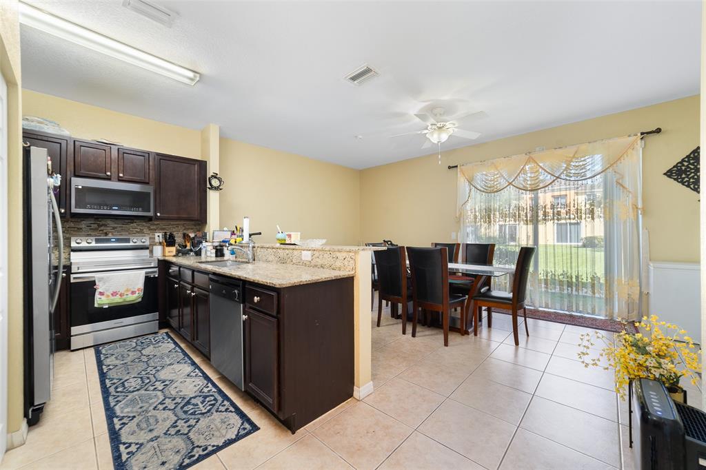 8915 Southwest 19th Street, Unit 8915 Miramar, FL 33025 - Photo 6 of 27 a kitchen with a sink refrigerator and cabinets