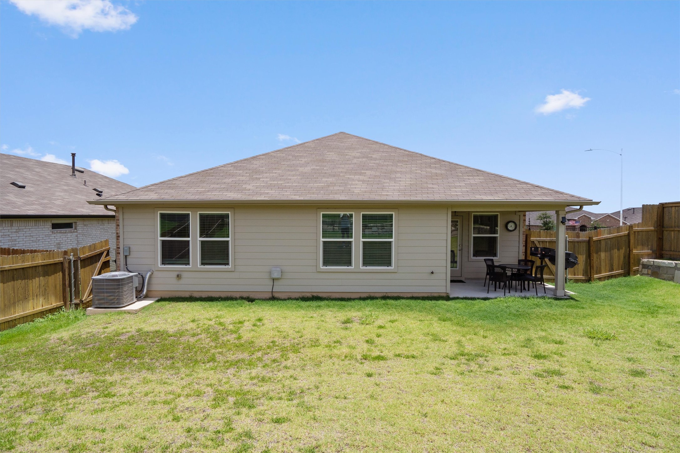 19525 Abigail Fillmore Road Manor, TX 78653 - Photo 30 of 38 A spacious backyard with a charming covered patio, perfect for outdoor dining and entertaining.