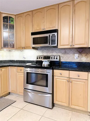 a kitchen with granite countertop white cabinets and stainless steel appliances