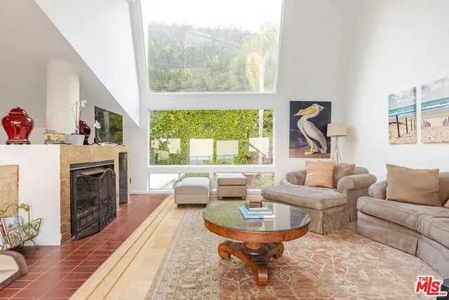 a living room with furniture a fireplace and a large window