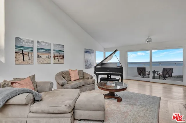 a living room with furniture a rug and kitchen view