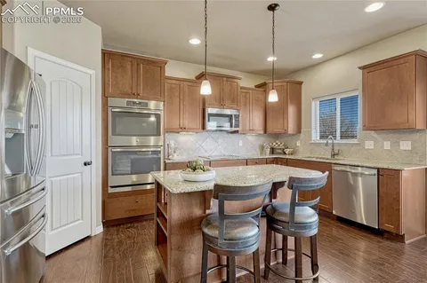 a kitchen with a table chairs refrigerator and microwave