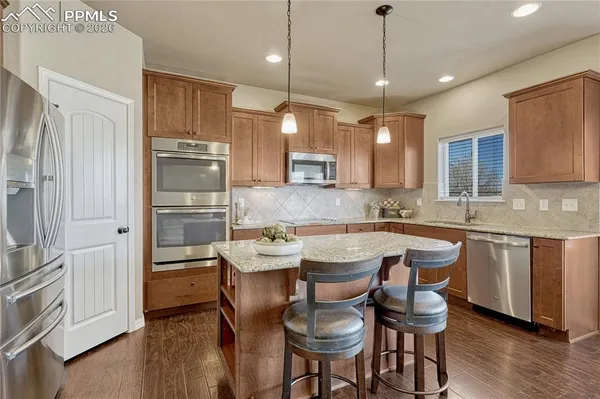 a kitchen with a table chairs refrigerator and microwave