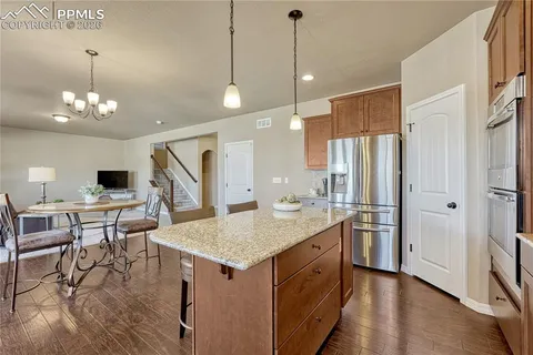 a kitchen with stainless steel appliances granite countertop a stove refrigerator and cabinets