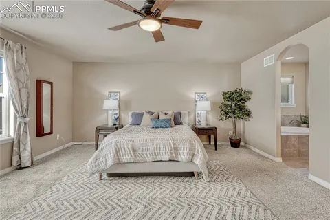 a bed room with a bed and a ceiling fan