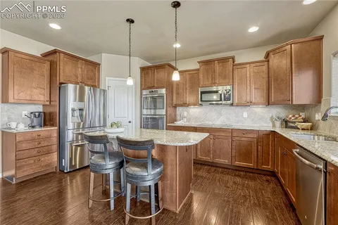 a view of a dining room and livingroom with furniture wooden floor a chandelier