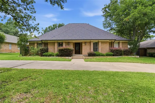 a front view of a house with yard and green space
