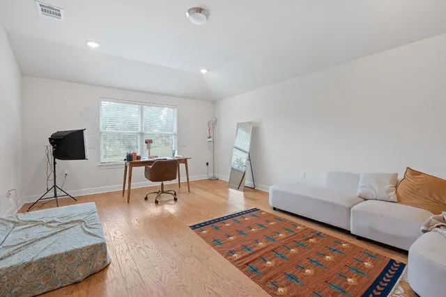 a bedroom with a bed and a flat tv screen on a dresser