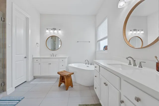 a bathroom with a double vanity sink mirror and shower