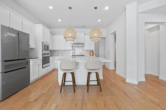 a kitchen with white cabinets and appliances
