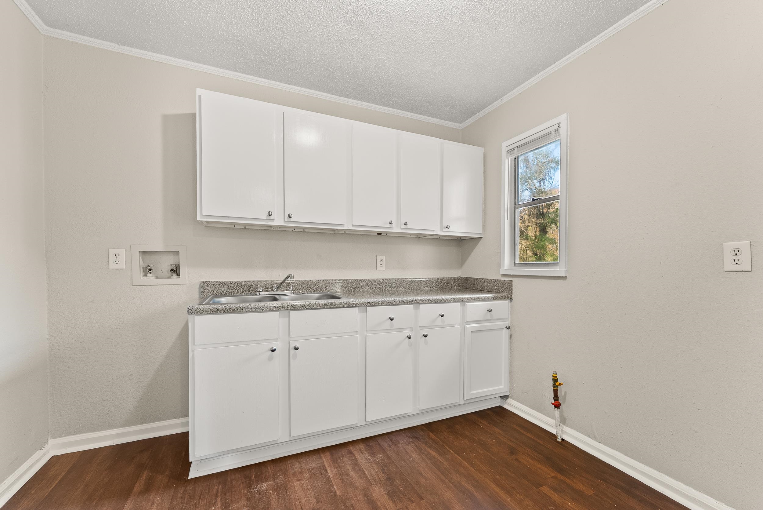 686 Delta Road Memphis, TN 38109 - Photo 11 of 24 a view of cabinets a sink and dishwasher with wooden floor