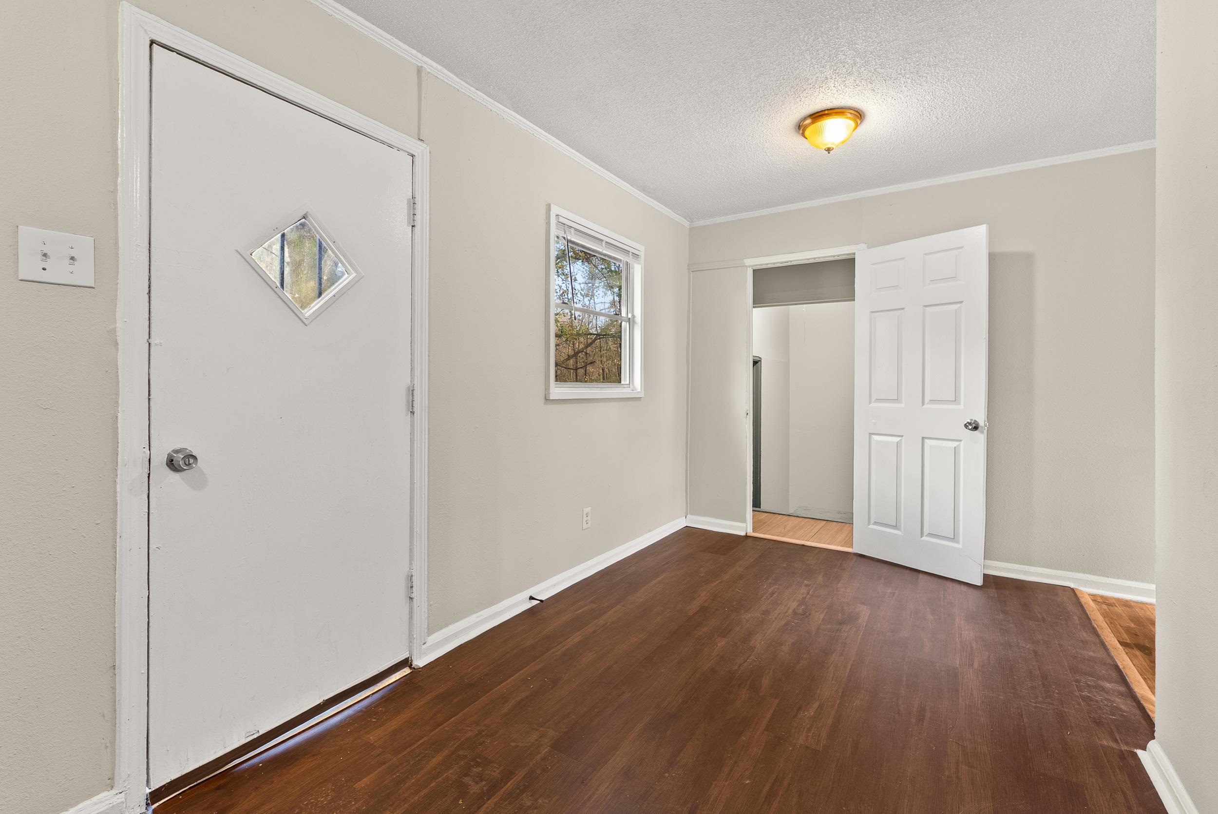 686 Delta Road Memphis, TN 38109 - Photo 7 of 24 an empty room with wooden floor and window