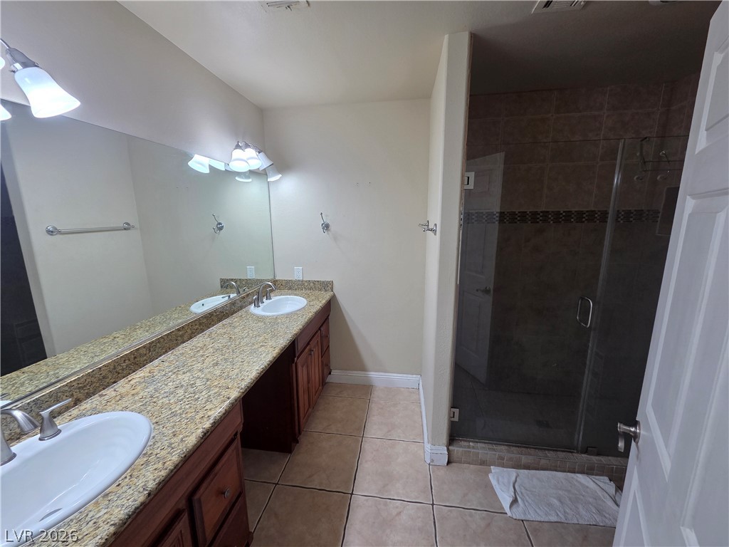 3381 Westwind Road Las Vegas, NV 89146 - Photo 25 of 52 Double vanities and a tiled walk-in shower elevate this contemporary bathroom.