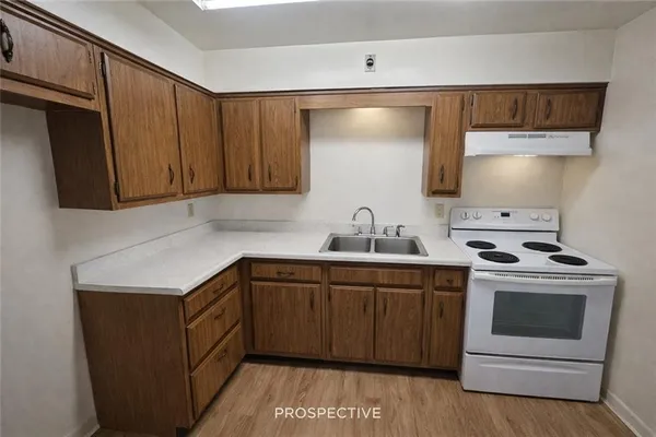 a kitchen with a stove sink and cabinets