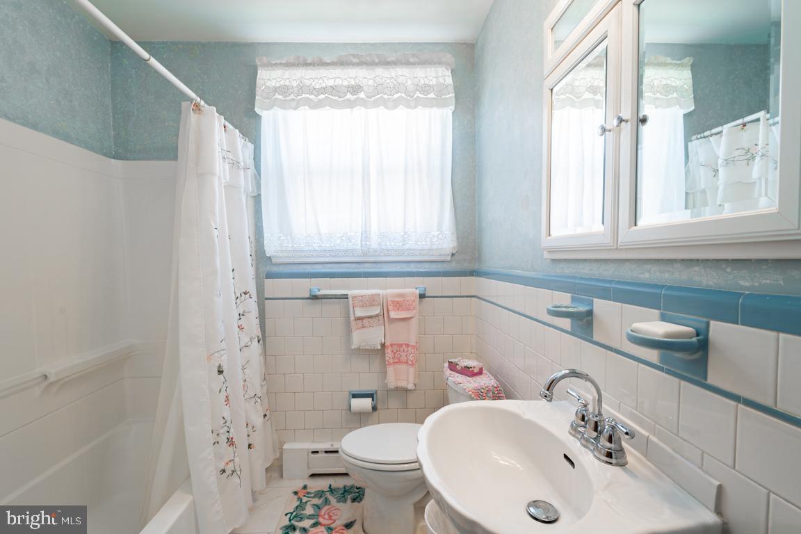 8504 Bassett Road Baltimore, MD 21237 - Photo 18 of 35 a bathroom with a sink a toilet and a window