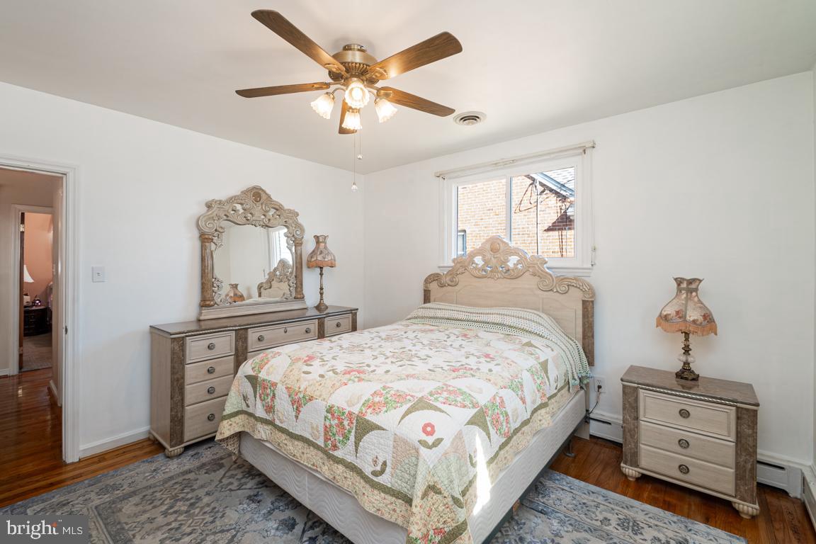 8504 Bassett Road Baltimore, MD 21237 - Photo 21 of 35 a bedroom with a bed a chandelier and dresser