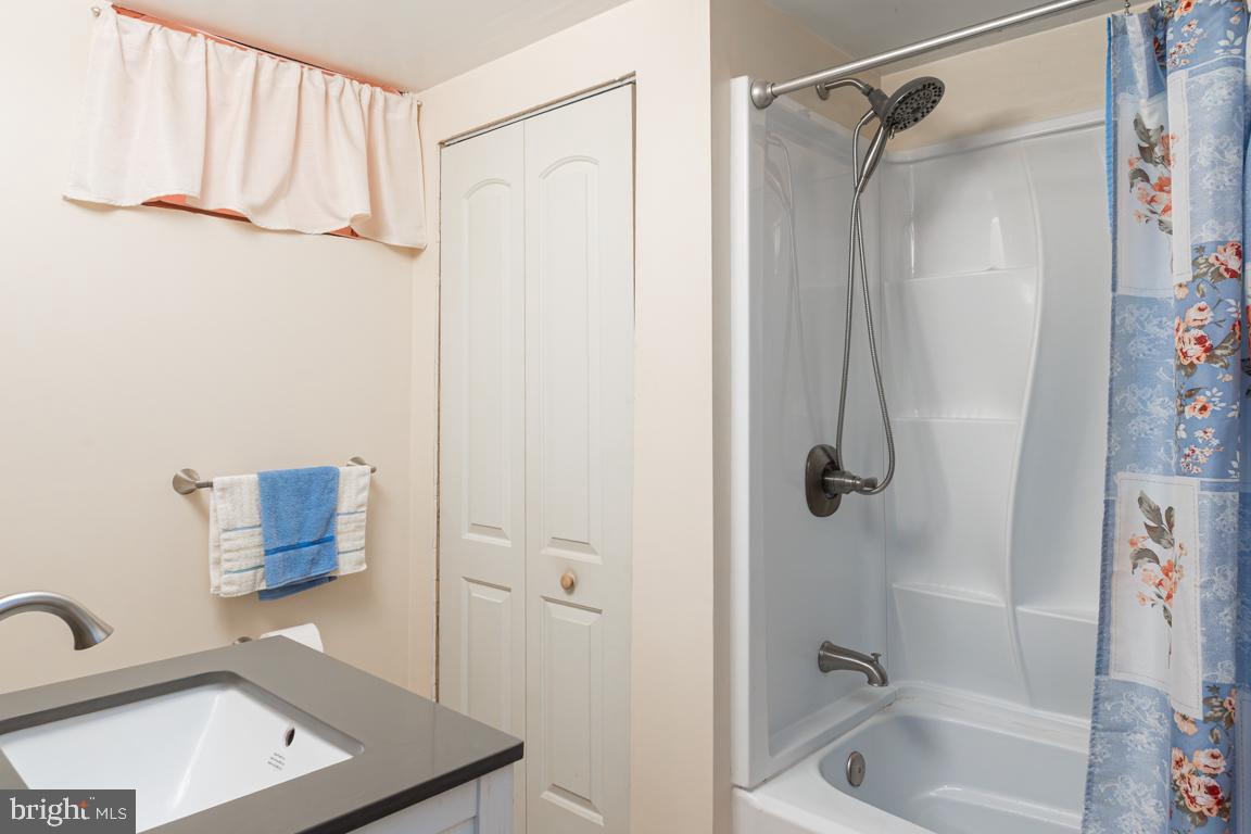 8504 Bassett Road Baltimore, MD 21237 - Photo 27 of 35 a bathroom with a shower curtain and a sink
