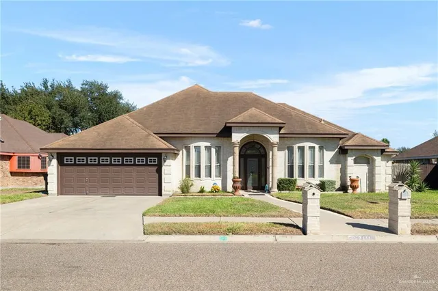 a front view of a house with a garden and plants