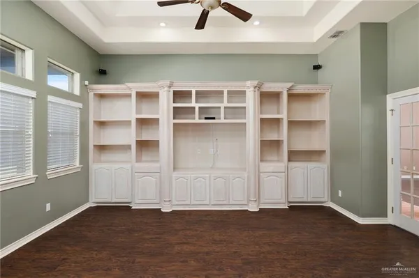 an empty room with cabinet and windows
