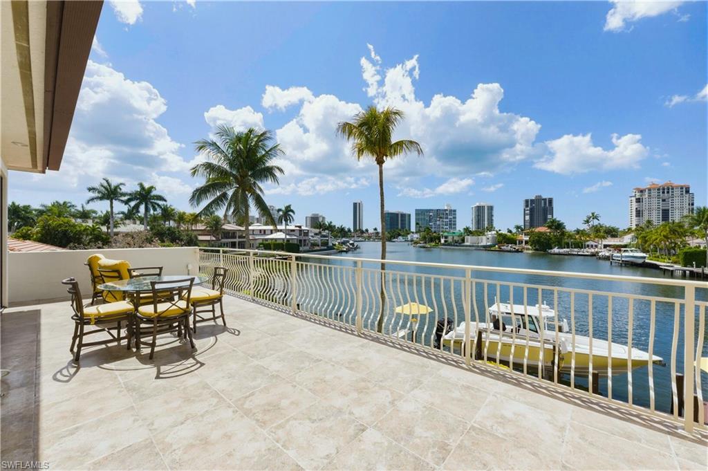 361 Pirates Bight Naples, FL 34103 - Photo 30 of 45 a view of a lake with a table and chairs