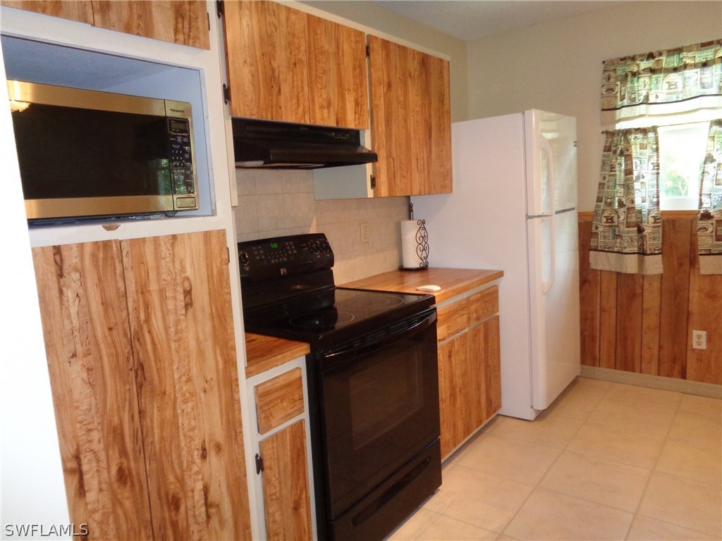 5458 Judith Road Bokeelia, FL 33922 - Photo 3 of 25 a kitchen with stainless steel appliances a refrigerator stove and microwave
