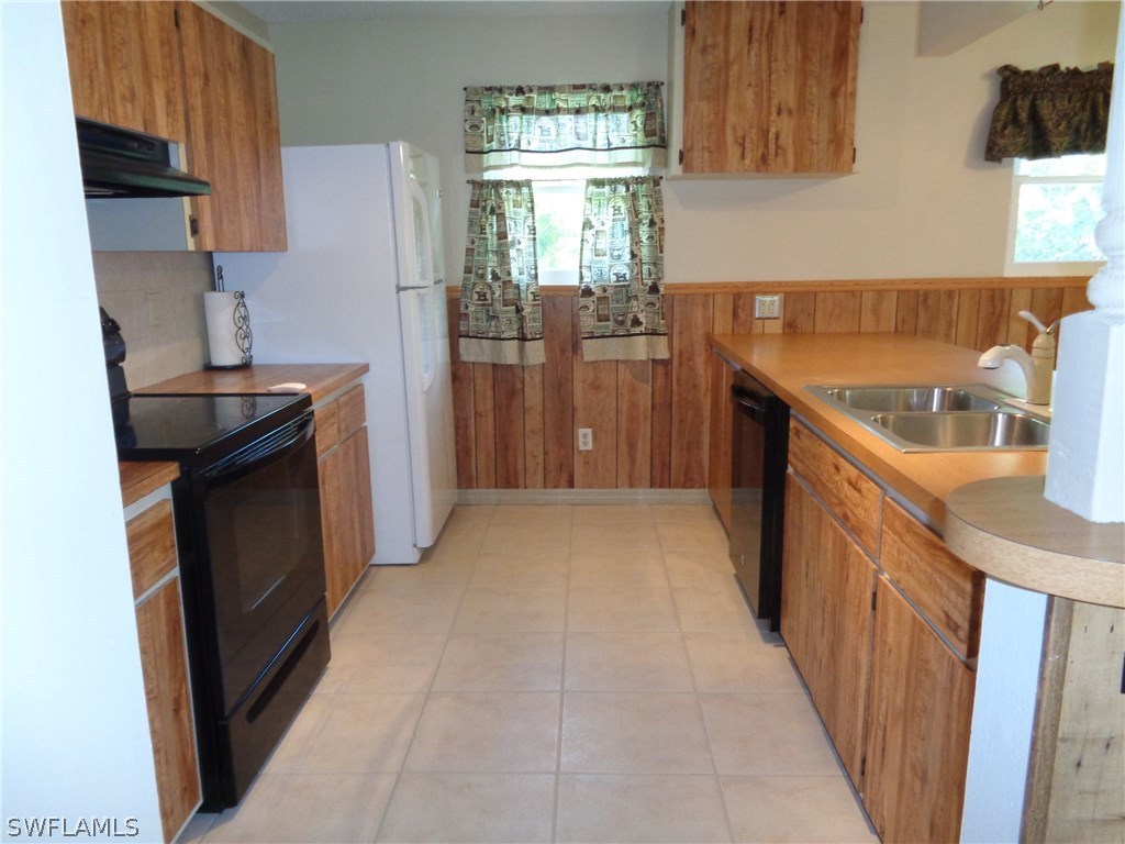 5458 Judith Road Bokeelia, FL 33922 - Photo 4 of 25 a kitchen with granite countertop a sink stove and refrigerator