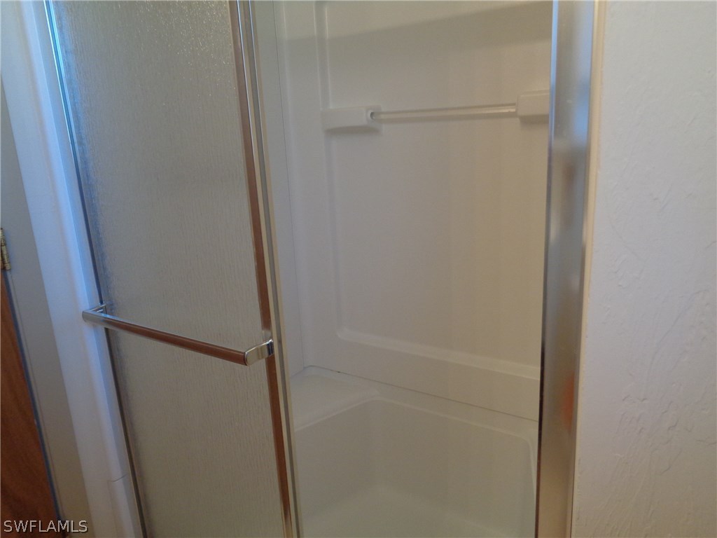 5458 Judith Road Bokeelia, FL 33922 - Photo 8 of 25 a bathroom with a glass shower door