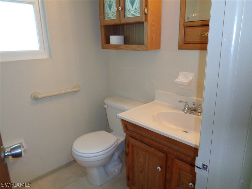 5458 Judith Road Bokeelia, FL 33922 - Photo 10 of 25 a bathroom with a sink a toilet and a mirror