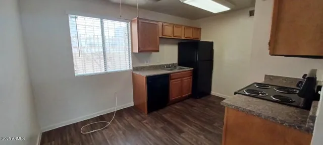 a kitchen with granite countertop a stove and a wooden floor